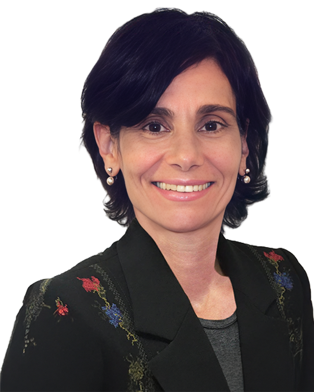 Smiling person with short dark hair, wearing a black jacket with floral patterns and pearl earrings.