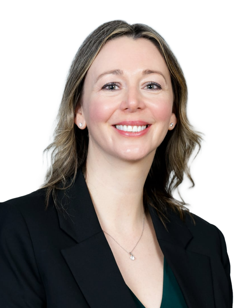 Portrait of a smiling woman in a black blazer, with a blurred background.
